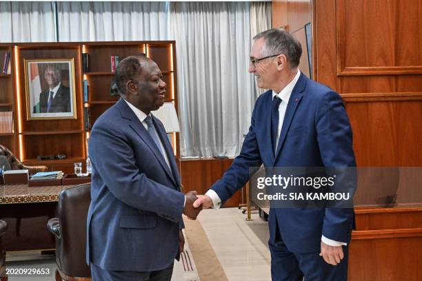 Ivorian President Alassane Ouattara shakes hands with Jean-Marie Bockel the personal envoy of French President Emmanuel Macron for Africa during a...