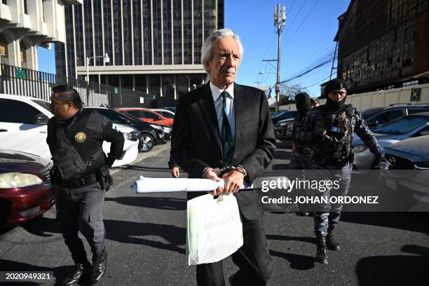 Guatemalan journalist José Rubén Zamora, founder of the defunct newspaper El Periódico, arrives handcuffed and escorted by police for a hearing at...