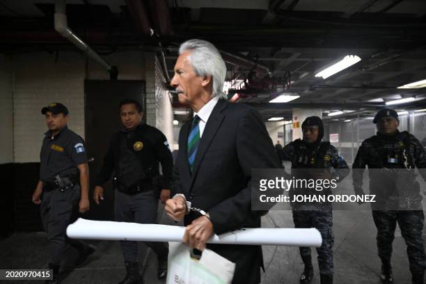 Guatemalan journalist José Rubén Zamora, founder of the defunct newspaper El Periódico, arrives handcuffed and escorted by police for a hearing at...