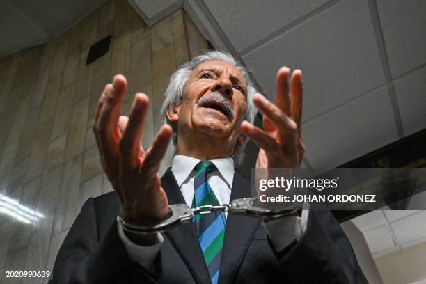 Guatemalan journalist Jose Ruben Zamora, founder of the now defunct newspaper El Periódico, speaks to journalists as he arrives handcuffed for a...