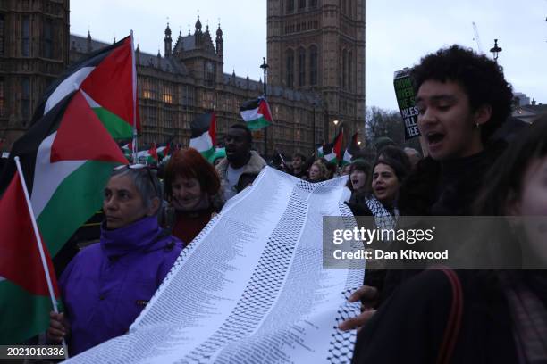 People carry a list of names of children killed in Gaza during a rally calling for a ceasefire, outside parliament as MPs consider a motion on Gaza...