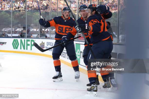 Mathew Barzal of the New York Islanders is congratulated by Bo Horvat and Brock Nelson after scoring a goal against the New York Rangers during the...