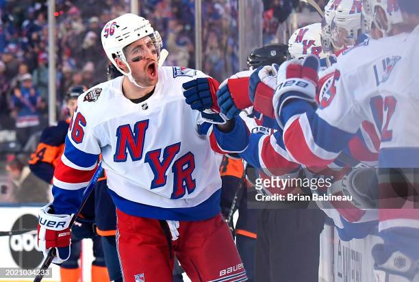 Erik Gustafsson of the New York Rangers skates by the team bench to celebrate his first period goal with teammates on the bench during the 2024 Navy...