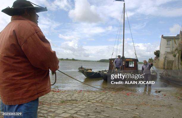 Des personnes habillées en costumes de marinier amarrent des bateaux en bord de Loire, le 05 mai 2005 à Ingrandes, près d'Angers, lors de la...