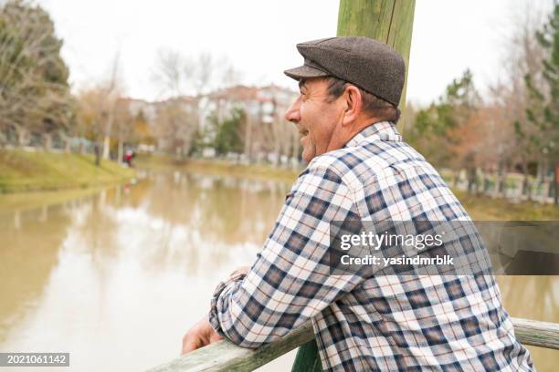 senior man watching the view on the pier in the park in the city center - queensland map stock pictures, royalty-free photos & images