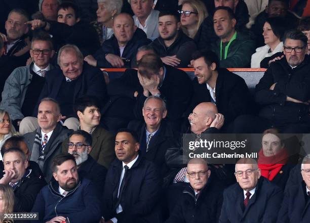 Singer Harry Styles interacts with Ezra Koenig, lead singer of rock band Vampire Weekend during the Premier League match between Luton Town and...