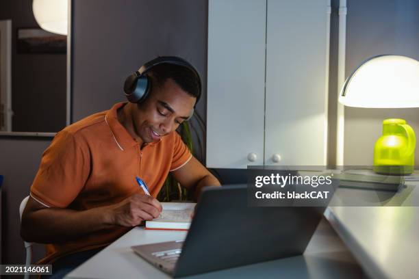 giovane che si concentra sul lavoro. lavorare fino a tardi a casa - educazione online foto e immagini stock