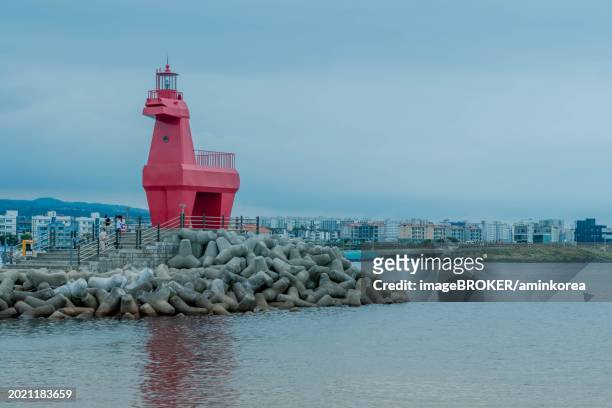 red lighthouse built to look like horse on concrete prier in jeju, south korea, asia - jeju horse stock pictures, royalty-free photos & images