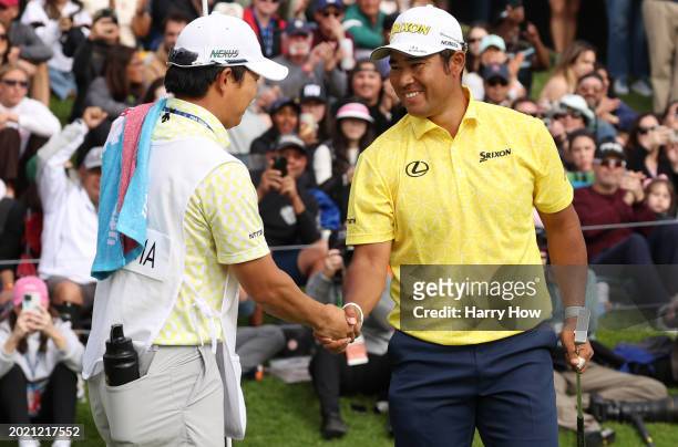 Hideki Matsuyama of Japan shakes hands with his caddie Shota Hayafuji after his winning putt on the 18th green during the final round of The Genesis...