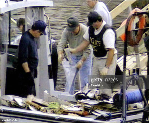 Grab from WTN Pictures shows Canadian police aboard a police boat searching through debris from Swissair Flight 111 and placing items in plastic bags...