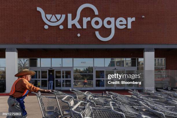 Worker pushes shopping carts outside a Kroger grocery store in Dallas, Texas, US, on Wednesday, Feb. 21, 2024. The US Federal Trade Commission and a...