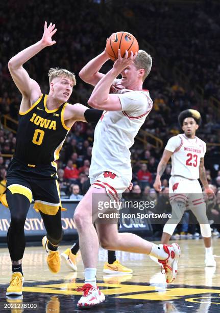Wisconsin forward Steven Crowl attempts a shot as Iowa center Even Brauns defends during a college basketball game between the Wisconsin Badgers and...