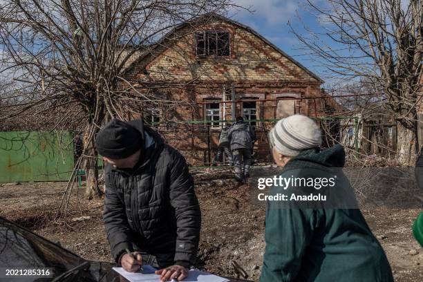 Residents gather next to Kostiantynivka city council worker collecting data from damaged houses after a Russian shelling over Kostiantynivka, Ukraine...