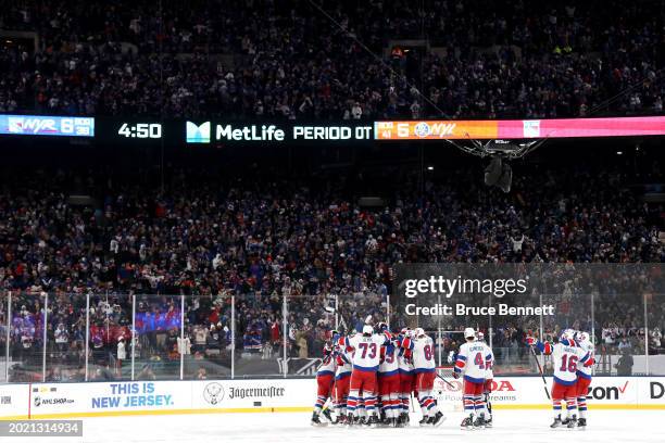 The New York Rangers celebrate their 6-5 overtime win against the New York Islanders during the 2024 Navy Federal Credit Union Stadium Series at...