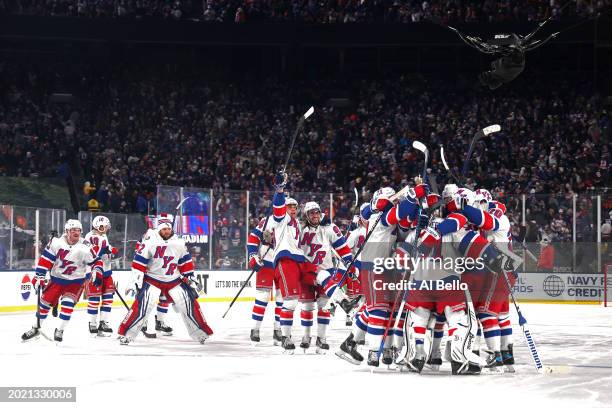 The New York Rangers celebrate their 6-5 overtime win against the New York Islanders during the 2024 Navy Federal Credit Union Stadium Series at...