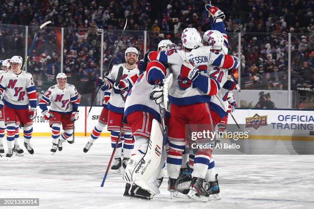 The New York Rangers celebrate their 6-5 overtime win against the New York Islanders during the 2024 Navy Federal Credit Union Stadium Series at...