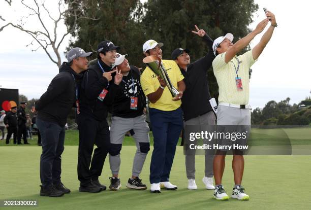 Hideki Matsuyama of Japan poses for a selfie with his caddie Shota Hayafuji and friends after his winning putt on the 18th green during the final...