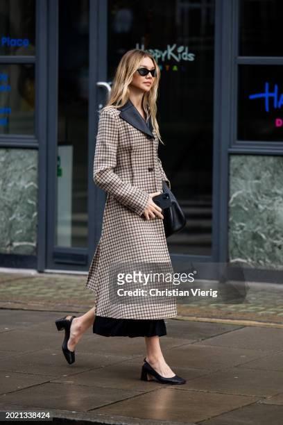 Jessie Andrews wears beige black checkered coat, skirt, heels, bag outside JW Anderson during London Fashion Week February 2024 on February 18, 2024...