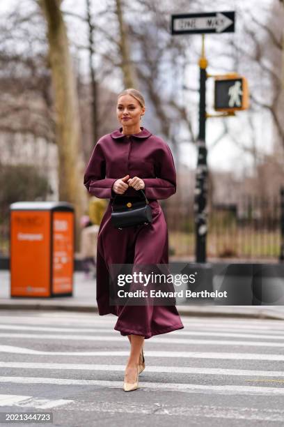 Guest wears a purple satin dress /shirt, a black leather bag, beige pointed shoes, outside Altuzarra, during New York Fashion Week, on February 11,...