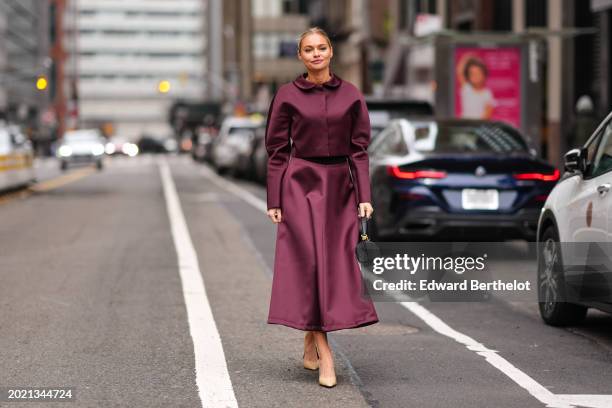 Guest wears a purple satin dress /shirt, a black leather bag, beige pointed shoes, outside Altuzarra, during New York Fashion Week, on February 11,...