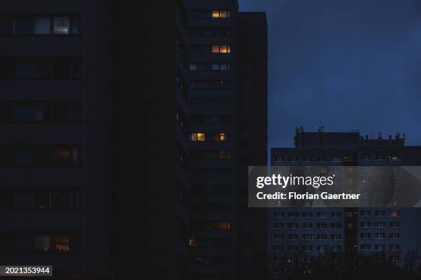 Lights shine through windows of a building during blue hour on February 20, 2024 in Berlin, Germany.