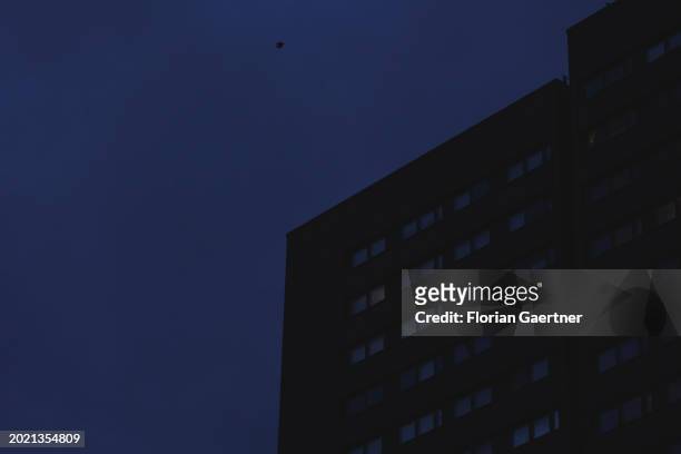 Lights shine through windows of a building during blue hour on February 20, 2024 in Berlin, Germany.