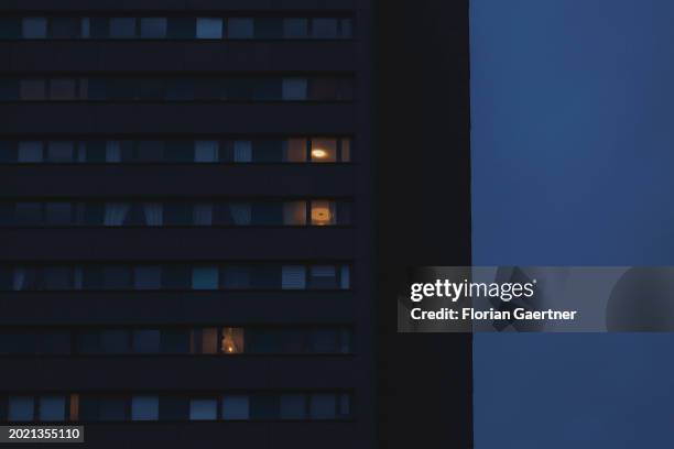 Lights shine through windows of a building during blue hour on February 20, 2024 in Berlin, Germany.