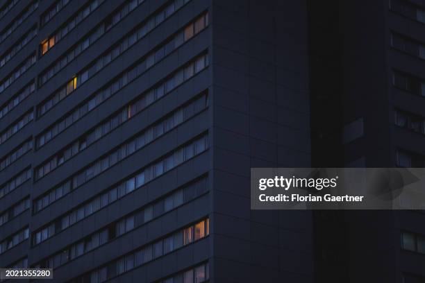 Lights shine through windows of a building during blue hour on February 20, 2024 in Berlin, Germany.