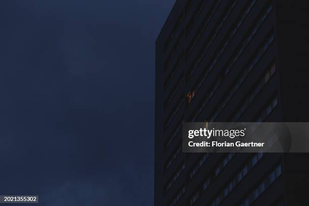 Lights shine through windows of a building during blue hour on February 20, 2024 in Berlin, Germany.