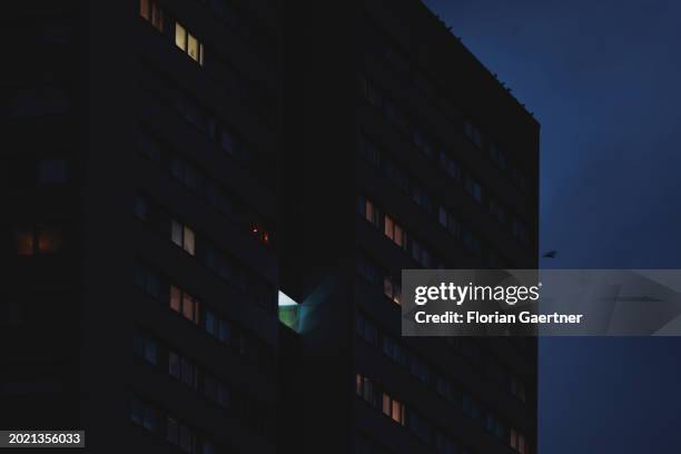 Lights shine through windows of a building during blue hour on February 20, 2024 in Berlin, Germany.