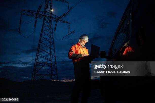 ökostrom. elektroingenieur, der nachts arbeitet. - energieerzeugung stock-fotos und bilder