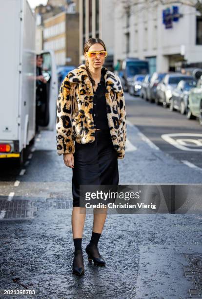 Isabella Charlotta Poppius wears animal print jacket, black cardigan, sunglasses, skirt, socks, heels outside Eudon Choi during London Fashion Week...