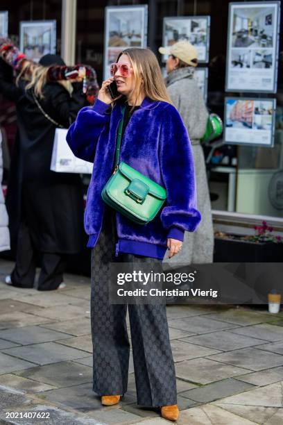 Guest wears green bag, blue coat, grey Gucci pants outside Eudon Choi during London Fashion Week February 2024 on February 18, 2024 in London,...