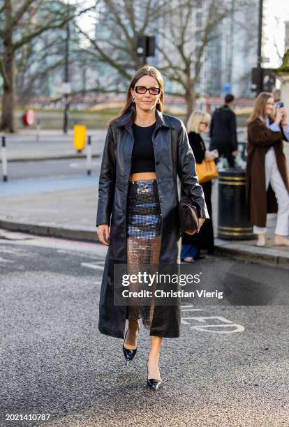 Chloe Street wears sequined transparent skirt, black leather pants, cropped top outside Holzweiler during London Fashion Week February 2024 on...