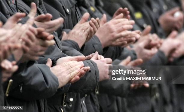 Russian special forces policemen applaud as they celebrate the "The Day of Police" at the Moscow's police station, 11 November 2004. According to...