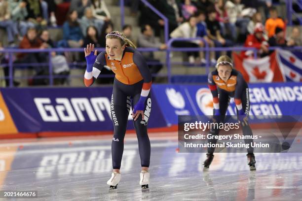 Joy Beune of the Netherlands waves to fans after skating the Woman's 1500m in front of Marjike Groenewoud of the Netherlands during day three of the...