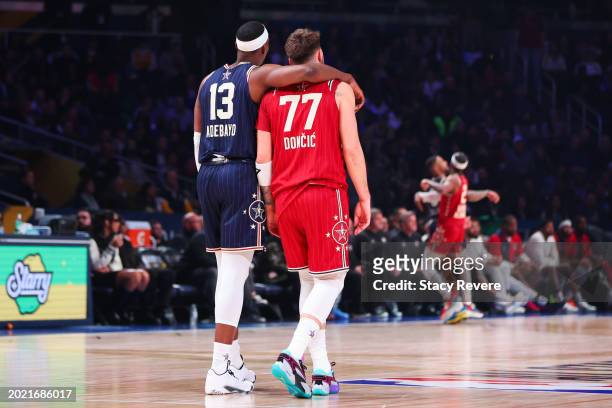 Bam Adebayo of the Miami Heat and Eastern Conference All-Stars and Luka Doncic of the Dallas Mavericks and Western Conference All-Stars embrace on...
