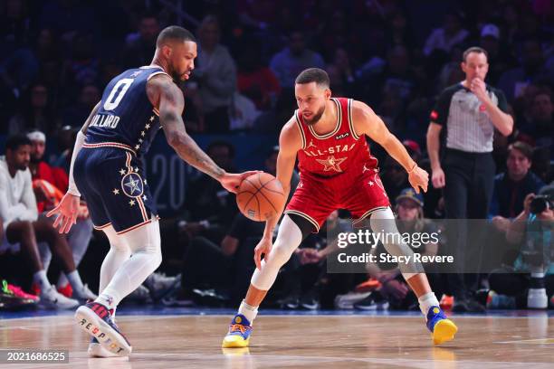 Damian Lillard of the Milwaukee Bucks and Eastern Conference All-Stars dribbles the ball against Stephen Curry of the Golden State Warriors and...