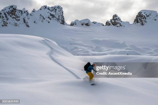 backcountry snowboarder descends mountain - telemark skiing stock pictures, royalty-free photos & images