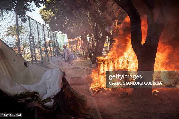 Makeshift structure in engulfed in flames as South African policemen and City of Cape Town law enforcement and marshals take down makeshift shelters...