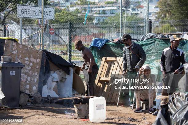 Homeless people pack their belongings as South African policemen and City of Cape Town law enforcement and marshals take down makeshift shelters as...