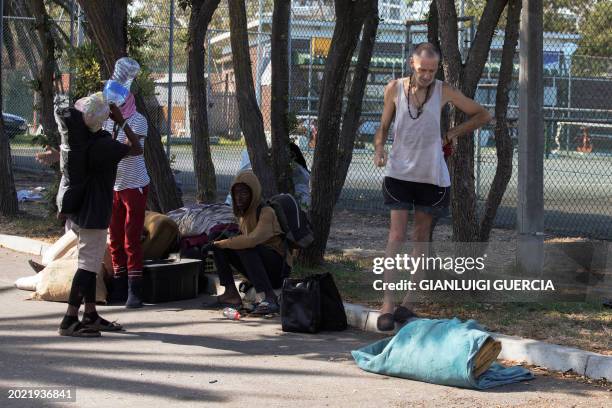 Homeless people pack their belongings as South African policemen and City of Cape Town law enforcement and marshals take down makeshift shelters as...