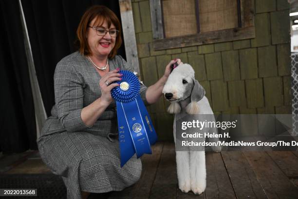Kellie Miller, of Arvada, holds up the blue ribbon her Tori, a four year old Bedlington Terrier, won in the Terrier group competition at the Colorado...