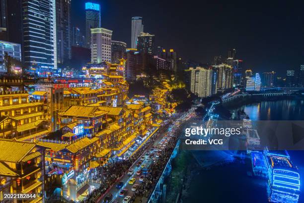 Tourists visit the Hongya Cave scenic spot at night on February 18, 2024 in Chongqing, China. Hongya Cave, formerly known as Hongya Gate, is one of...