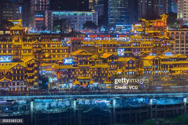 Tourists visit the Hongya Cave scenic spot at night on February 18, 2024 in Chongqing, China. Hongya Cave, formerly known as Hongya Gate, is one of...