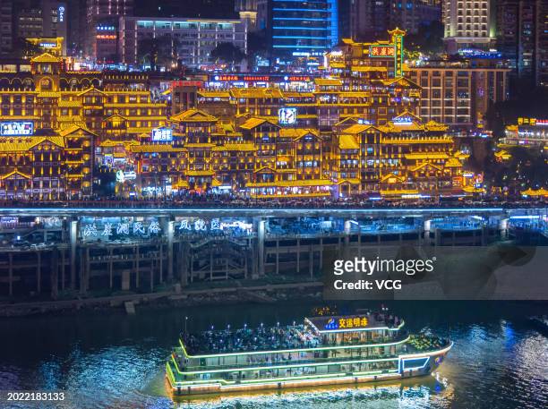 Tourists visit the Hongya Cave scenic spot at night on February 18, 2024 in Chongqing, China. Hongya Cave, formerly known as Hongya Gate, is one of...