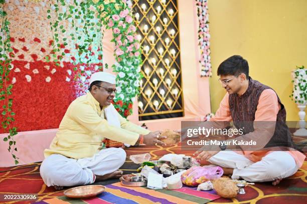 young man along with the priest making preparations for the wedding ceremony - indian priest stock pictures, royalty-free photos & images