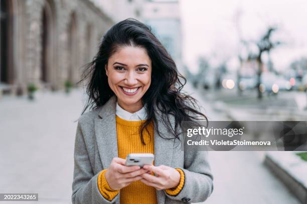 woman using smartphone outdoors. - good news stock pictures, royalty-free photos & images