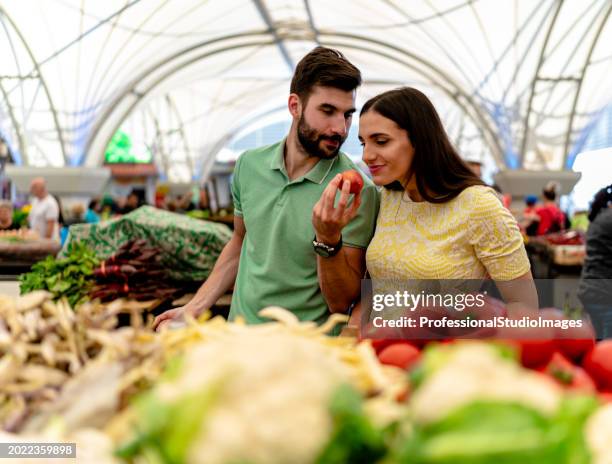 couple explores the vibrant delights of the street market - young couple grocery store stock pictures, royalty-free photos & images