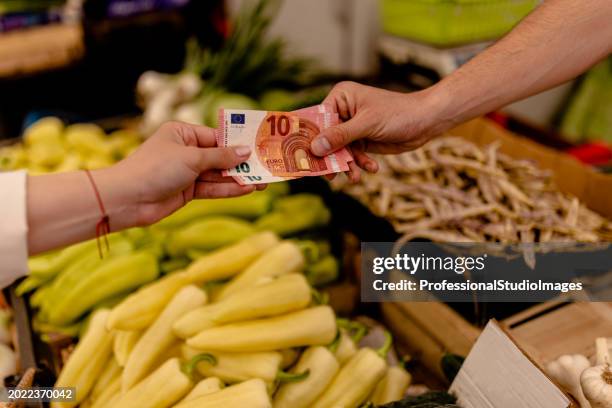 customers opt for cash payments to stay on budget at the street market - market stall stock pictures, royalty-free photos & images